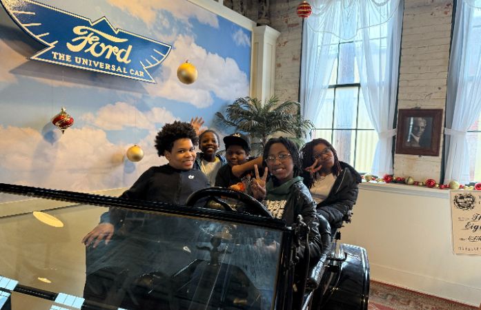  5 students sitting in a replica Model T